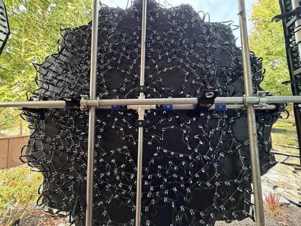 Back of a large round prop on scaffolding showing hundreds of looped pixel wires