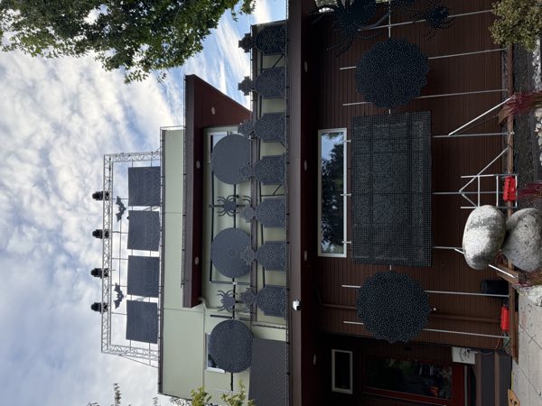 Pixel panels, spiders, and webs mounted across the front of the house during setup