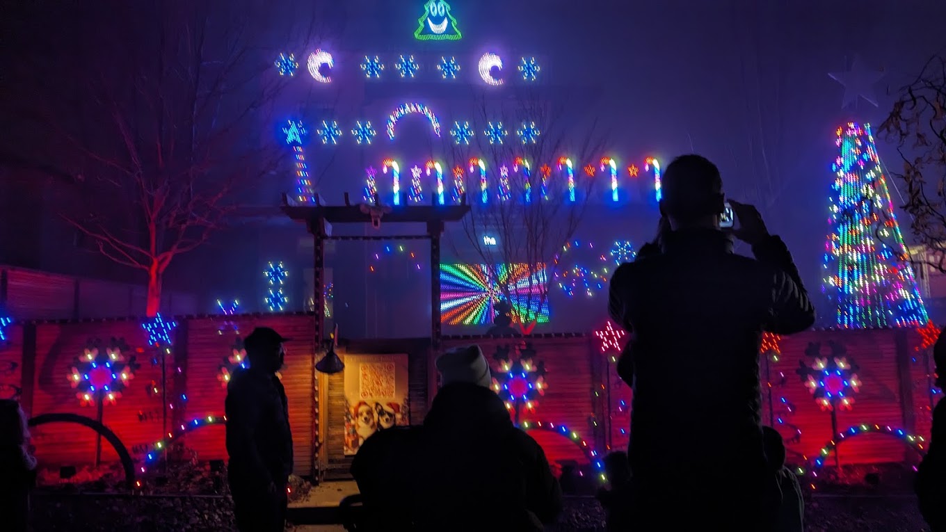 Visitors taking photos of the blue and purple Christmas display