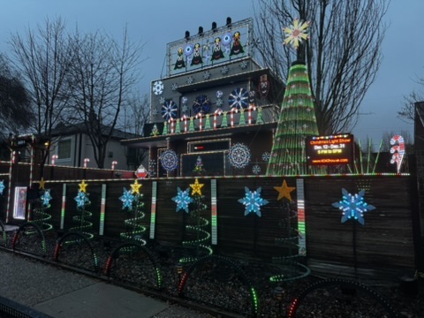Christmas display at dusk with stars and snowflakes along the fence