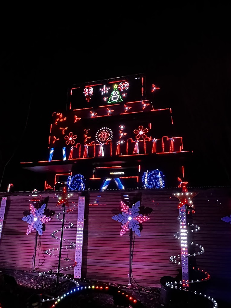 Christmas display in red with candy canes on the house and snowflakes along the fence